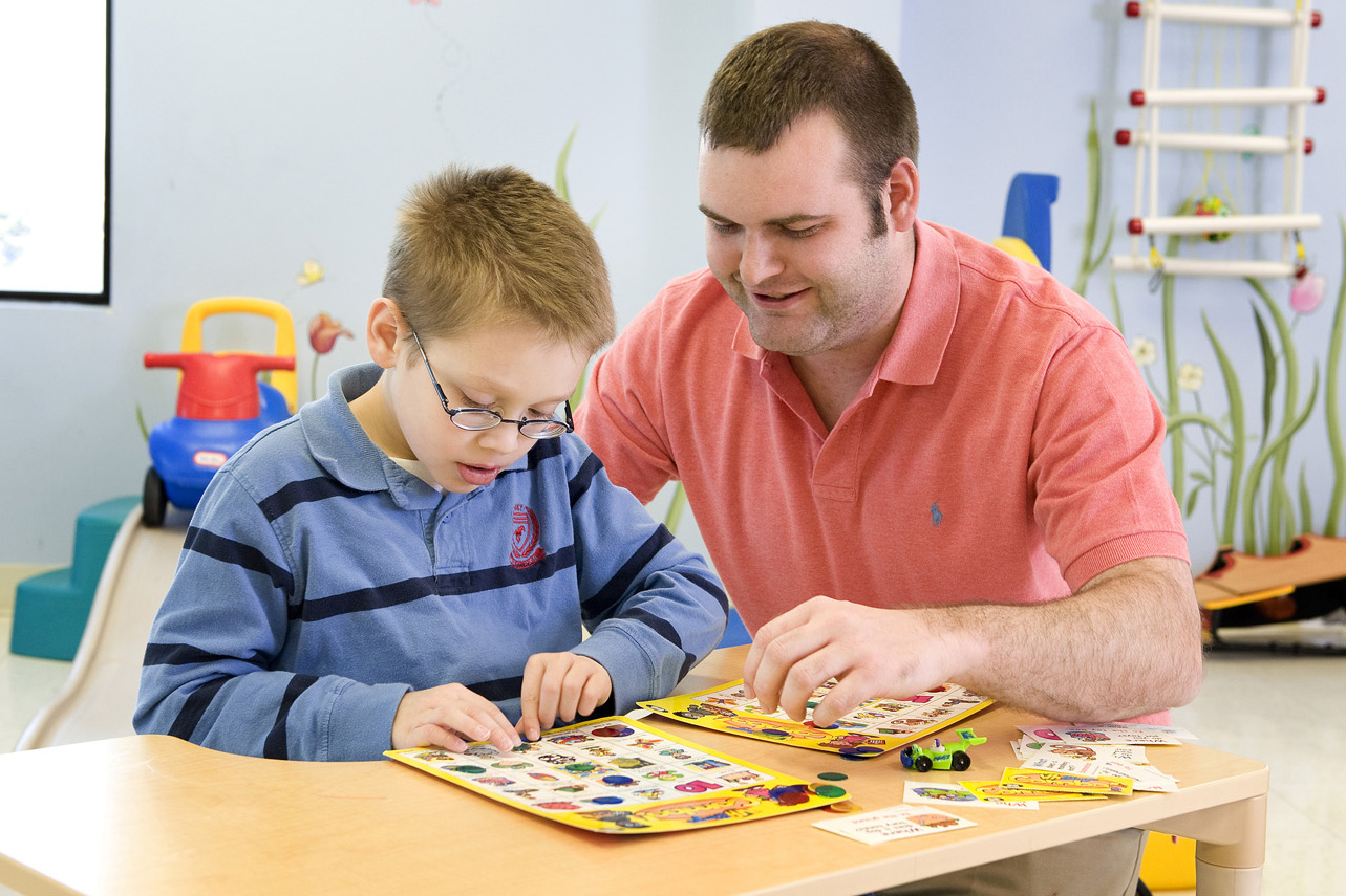 speech pathologist working with young boy